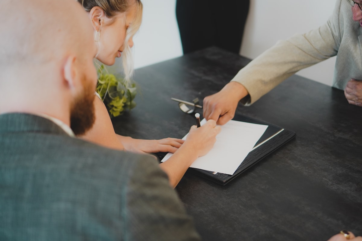A couple signing documents at a desk